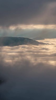 Büyülü bir günün dikey hızlandırılmış sabahında doğa bulutlar arasında değişen bir pencereden belirir. Yumuşak sis ve altın ışık sisli bir vadi üzerinde akıyor, rüya gibi, huzurlu ve