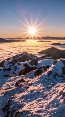 Karlı dağların tepelerinde yükselen parlak güneş yıldızları vadideki sisli bulutlar gibi huzur dolu Alpler doğasında akıyor. Sakin kış sabahı gündoğumu, açık hava macerası, dağcılık ve yürüyüş için ideal.