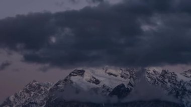 Kafkasya Dağları 'ndaki Tetnuldi Tepesi' nin üzerinde şafağın barışçıl hızıyla alçak bulutlar yükselirken sıcak güneş ışığı sırtları boyarken parlak, karla kaplı bir zirveyi gözler önüne seriyor. İdeal