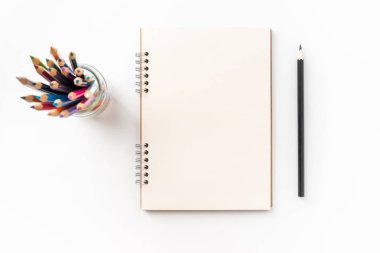 Tasarım konsepti - kraft spiral defter, boş sayfa, kalem sahibi ve renk kalem mockup için beyaz arka plan üzerinde izole üstten görünüm