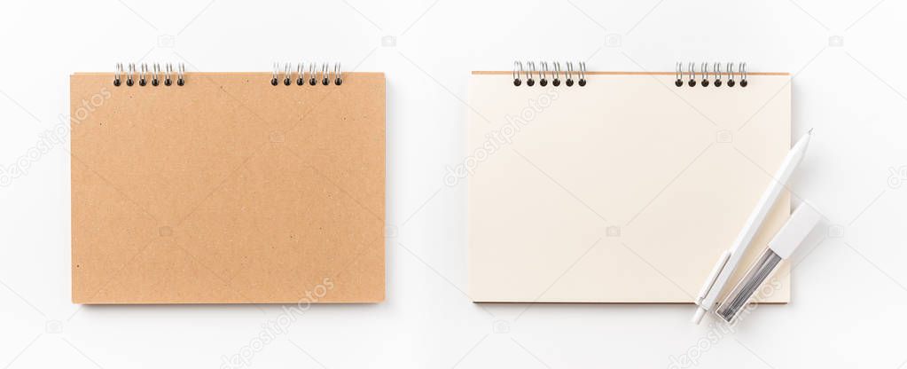 Design concept - Top view of kraft spiral notebook, blank page and wood pen isolated on white background for mockup