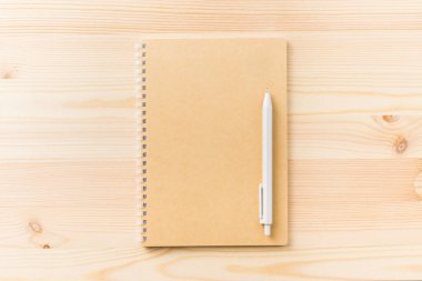 Tasarım konsepti - mockup için ahşap masa arka plan üzerinde siyah kraft spiral defter ve mekanik kurşun kalem üstten görünüm