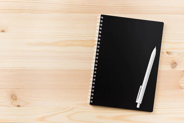 设计理念 黑色螺旋笔记本和木笔的顶部视图在木桌上的样机背景 — 图库照片