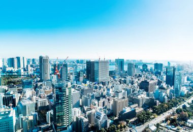 Asya iş kavramı Emlak ve kurumsal inşaat - parlak güneş ve Tokyo, Japonya'da canlı mavi gökyüzü altında tokyo tower yakınındaki Vinçli panoramik modern şehir manzarası kuş göz havadan görünümü