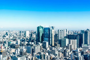 Asya iş kavramı Emlak ve kurumsal inşaat - parlak güneş ve Tokyo, Japonya'da canlı mavi gökyüzü altında tokyo tower yakınındaki panoramik modern şehir manzarası kuş gözü havadan görünümü