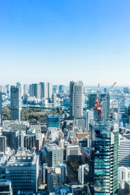Asya iş kavramı Emlak ve kurumsal inşaat - parlak güneş ve Tokyo, Japonya'da canlı mavi gökyüzü altında tokyo tower yakınındaki Vinçli panoramik modern şehir manzarası kuş göz havadan görünümü