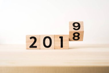 İş ve tasarım kavramı - gerçeküstü soyut geometrik yüzen tahta küp ahşap zemin ve beyaz arka plan üzerinde kelime 2019 ve 2018 konseptiyle