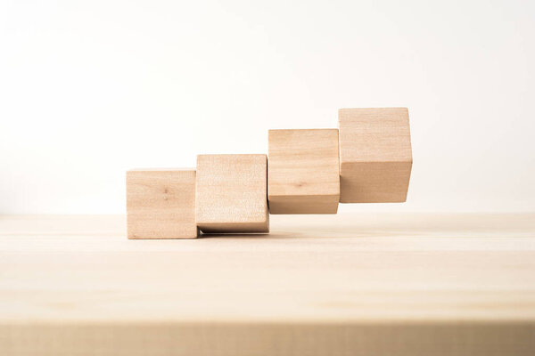 Концепция дизайна - абстрактный геометрический реальный деревянный куб с сюрреалистической планировкой на фоне деревянного пола и это не 3D рендеринг
