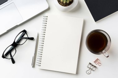 İş kavramı - beyaz okul sırası geçmiş ile defter, kahve, akıllı telefon, kaktüs ve klibi mockup tasarım için en iyi görünümü