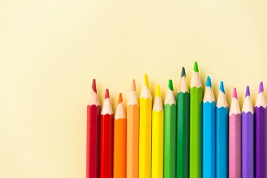 Sanat kavramı - mockup tasarım için sarı Kağıt arka plan üzerinde renkli kalem üstten görünüm