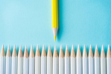 İş kavramı - beyaz kalem ve renk kalem mavi Kağıt arka plan üzerinde çok. Bu sembol, kavga, liderlik ve iletişim.