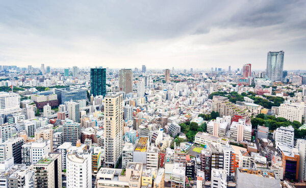 Business and culture concept - panoramic modern city skyline bird eye aerial view from tokyo tower under dramatic grey cloudy sky in Tokyo, Japan