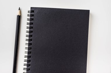 İş kavramı - Siyah spiral defter ve siyah kalem mockup için arka plan üzerinde izole üstten görünüm koleksiyonu