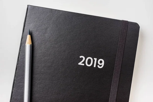 İş kavramı - siyah ciltli defter ve word 2019 ile gümüş kalem üstten görünüm koleksiyonu mockup için arka plan üzerinde izole