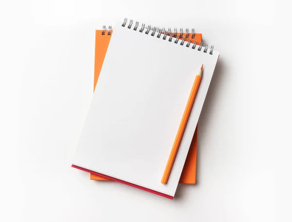 デザイン コンセプト オレンジと赤のスパイラル ノートと色鉛筆コレクションがモックアップの白い背景で隔離の平面図 — ストック写真