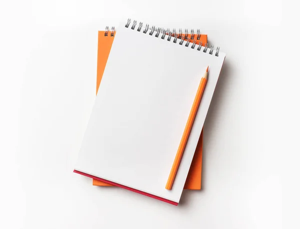 Tasarım konsepti - turuncu ve kırmızı spiral defter ve renk kalem toplama mockup için beyaz arka plan üzerinde izole üstten görünüm