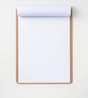 Mockup için beyaz arka plan üzerinde izole kahverengi pano üzerinde beyaz A4 çevrilmiş kağıt üst görünümü.