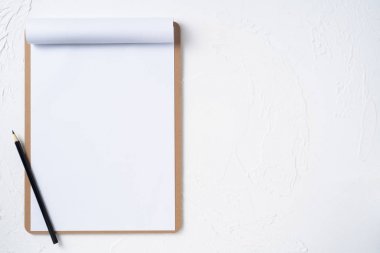 Mockup için beyaz arka plan üzerinde siyah kalem ile kahverengi pano üzerinde A4 çevrilmiş kağıt.
