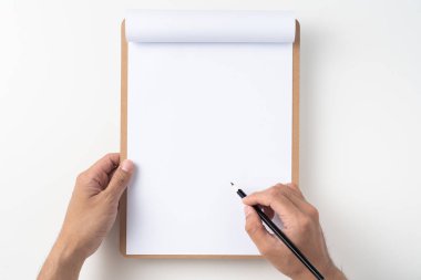Beyaz a4 üzerinde kalem tutan erkek elleri üst görünümü beyaz arka plan üzerinde izole kahverengi pano ile çevrilmiş kağıt.