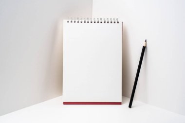 Maket için beyaz arka plan üzerinde siyah kalem ile kırmızı spiral defter.