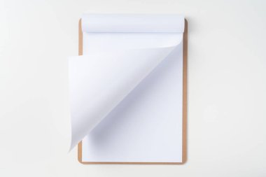 Mockup için beyaz arka plan üzerinde izole kahverengi pano üzerinde beyaz A4 çevrilmiş kağıt üst görünümü.