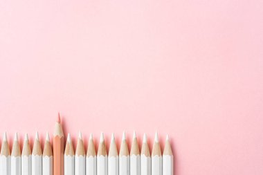 İş ve tasarım konsepti - beyaz kalem ve pembe kağıt arka plan üzerinde bir renk kalem çok. Liderlik, takım çalışması, başarı ve benzersiz sembolü.