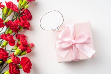 Kopya alanı ile arka planda kırmızı karanfil ve hediye kutusu buketi