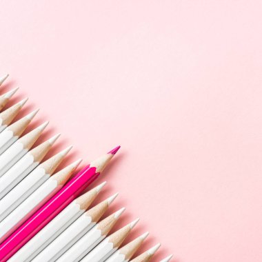 İş ve tasarım konsepti - beyaz kalem ve pembe kağıt arka plan üzerinde bir renk kalem çok. Liderlik, takım çalışması, başarı ve benzersiz sembolü.