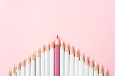 İş ve tasarım konsepti - beyaz kalem ve pembe kağıt arka plan üzerinde bir renk kalem çok. Liderlik, takım çalışması, başarı ve benzersiz sembolü.