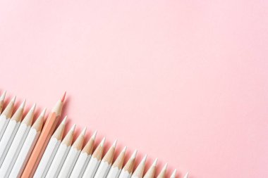 İş ve tasarım konsepti - beyaz kalem ve pembe kağıt arka plan üzerinde bir renk kalem çok. Liderlik, takım çalışması, başarı ve benzersiz sembolü.