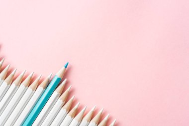 İş ve tasarım konsepti - beyaz kalem ve pembe kağıt arka plan üzerinde bir renk kalem çok. Liderlik, takım çalışması, başarı ve benzersiz sembolü.