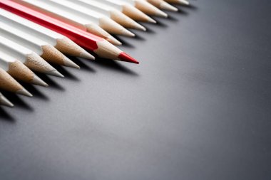 İş ve tasarım konsepti - beyaz kalem ve siyah arka plan üzerinde bir renk kalem çok. Liderlik, takım çalışması, başarı ve benzersiz sembolü.