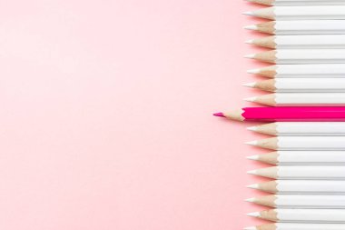 İş ve tasarım konsepti - beyaz kalem ve pembe kağıt arka plan üzerinde bir renk kalem çok. Liderlik, takım çalışması, başarı ve benzersiz sembolü.