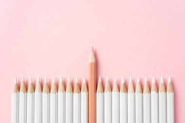 İş ve tasarım konsepti - beyaz kalem ve pembe kağıt arka plan üzerinde bir renk kalem çok. Liderlik, takım çalışması, başarı ve benzersiz sembolü.