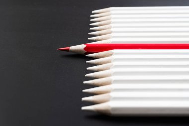 İş ve tasarım konsepti - beyaz kalem ve siyah arka plan üzerinde bir renk kalem çok. Liderlik, takım çalışması, başarı ve benzersiz sembolü.