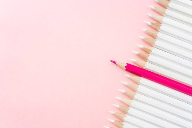 İş ve tasarım konsepti - beyaz kalem ve pembe kağıt arka plan üzerinde bir renk kalem çok. Liderlik, takım çalışması, başarı ve benzersiz sembolü.