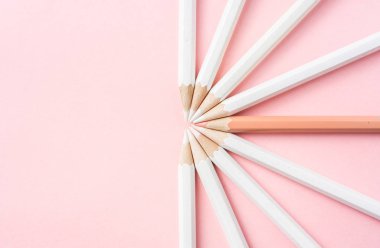İş ve tasarım konsepti - beyaz kalem ve pembe kağıt arka plan üzerinde bir renk kalem çok. Liderlik, takım çalışması, başarı ve benzersiz sembolü.