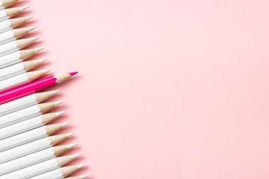 İş ve tasarım konsepti - beyaz kalem ve pembe kağıt arka plan üzerinde bir renk kalem çok. Liderlik, takım çalışması, başarı ve benzersiz sembolü.