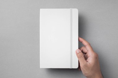 Tasarım konsepti - gri arka planda elastik bantlı beyaz dizüstü bilgisayarı tutan en iyi görünüm erkek el.