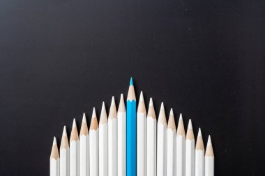 İş ve tasarım konsepti - beyaz kalem ve siyah arka plan üzerinde bir renk kalem çok. Liderlik, takım çalışması, başarı ve benzersiz sembolü.