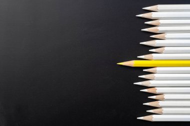 İş ve tasarım konsepti - beyaz kalem ve siyah arka plan üzerinde bir renk kalem çok. Liderlik, takım çalışması, başarı ve benzersiz sembolü.