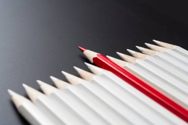 İş ve tasarım konsepti - beyaz kalem ve siyah arka plan üzerinde bir renk kalem çok. Liderlik, takım çalışması, başarı ve benzersiz sembolü.