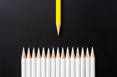 İş ve tasarım konsepti - beyaz kalem ve siyah arka plan üzerinde bir renk kalem çok. Liderlik, takım çalışması, başarı ve benzersiz sembolü.