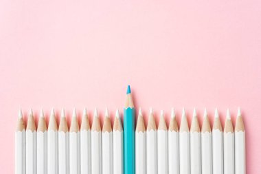 İş ve tasarım konsepti - beyaz kalem ve pembe kağıt arka plan üzerinde bir renk kalem çok. Liderlik, takım çalışması, başarı ve benzersiz sembolü.