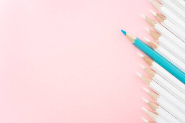 İş ve tasarım konsepti - beyaz kalem ve pembe kağıt arka plan üzerinde bir renk kalem çok. Liderlik, takım çalışması, başarı ve benzersiz sembolü.