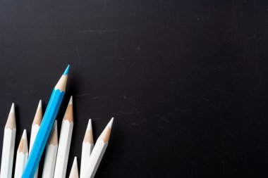 İş ve tasarım konsepti - beyaz kalem ve siyah arka plan üzerinde bir renk kalem çok. Liderlik, takım çalışması, başarı ve benzersiz sembolü.