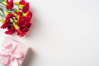 Kopya alanı ile arka planda kırmızı karanfil ve hediye kutusu buketi