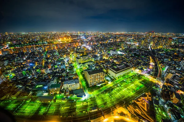 Gayrimenkul ve kurumsal inşaat için Asya İş kavramı - Tokyo, Japonya'da alacakaranlık gökyüzü ve neon gece altında panoramik kentsel şehir silueti hava görünümü.