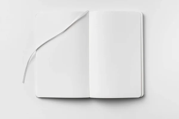 モックアップ用の白い背景に隔離された白いノートブックとリボンブックマークを開きました — ストック写真