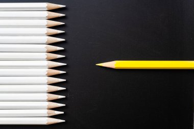 İş ve tasarım konsepti - beyaz kalem ve siyah arka plan üzerinde bir renk kalem çok. Liderlik, takım çalışması, başarı ve benzersiz sembolü.